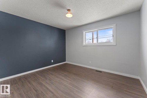 Spare room featuring wood finished floors and a textured ceiling - 4719 47 Avenue, Cold Lake, AB - Indoor Photo Showing Other Room