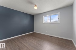 Spare room featuring wood finished floors and a textured ceiling - 