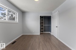 Unfurnished bedroom with a textured ceiling, dark wood finished floors, and a closet - 