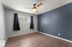 Unfurnished room featuring wood finished floors, a ceiling fan, and a textured ceiling - 