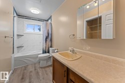 Bathroom with shower / bathtub combination with curtain, light wood finished floors, and vanity - 