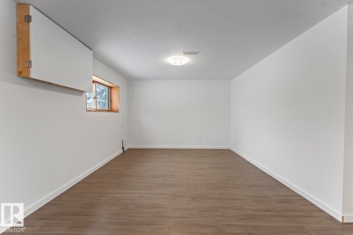 Spare room featuring dark wood-style floors and baseboards - 4719 47 Avenue, Cold Lake, AB - Indoor Photo Showing Other Room