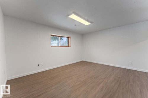 Empty room featuring dark wood-style floors and baseboards - 4719 47 Avenue, Cold Lake, AB - Indoor Photo Showing Other Room