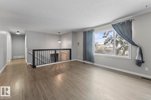 Empty room with a textured ceiling and wood finished floors - 4719 47 Avenue, Cold Lake, AB - Indoor Photo Showing Other Room
