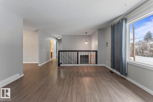 Unfurnished room featuring dark wood-style floors and a textured ceiling - 4719 47 Avenue, Cold Lake, AB - Indoor Photo Showing Other Room