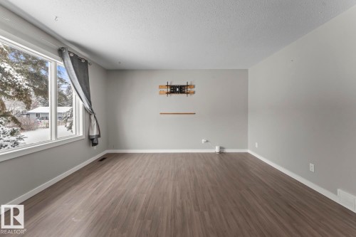 Unfurnished room with wood finished floors and a textured ceiling - 4719 47 Avenue, Cold Lake, AB - Indoor Photo Showing Other Room
