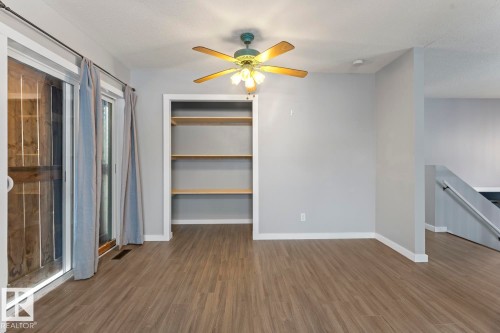 Unfurnished living room featuring dark wood-style floors, a ceiling fan, and a textured ceiling - 4719 47 Avenue, Cold Lake, AB - Indoor Photo Showing Other Room