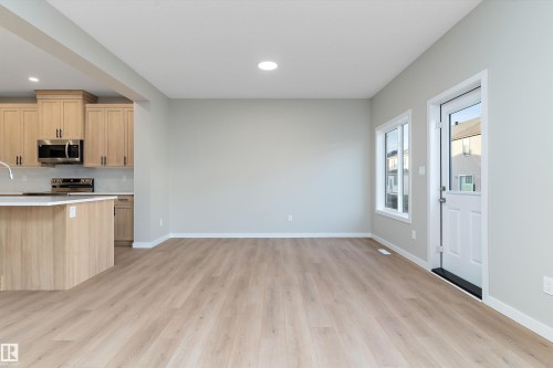 Kitchen with light brown cabinetry, stainless steel appliances, light wood-type flooring, recessed lighting, and light stone counters - 6320 King Wynd, Edmonton, AB - Indoor Photo Showing Kitchen
