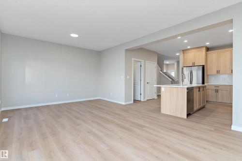 Kitchen with light brown cabinets, a center island with sink, light wood-style floors, open floor plan, and recessed lighting - 6320 King Wynd, Edmonton, AB - Indoor Photo Showing Kitchen