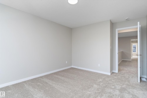 Empty room with light colored carpet and baseboards - 6320 King Wynd, Edmonton, AB - Indoor Photo Showing Other Room