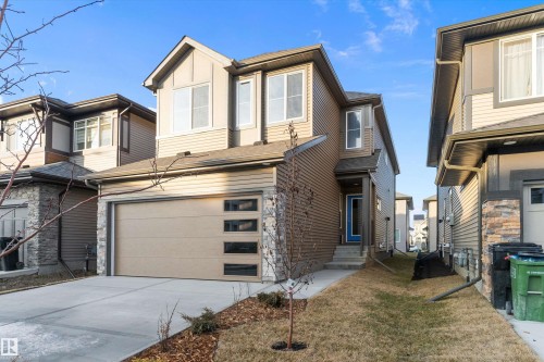 View of front of house featuring driveway, a front yard, and an attached garage - 6320 King Wynd, Edmonton, AB - Outdoor