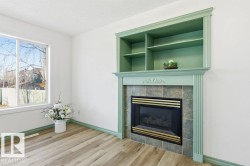 Unfurnished living room with a tile fireplace, light wood-type flooring, a textured ceiling, and built in features - 