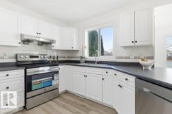 Kitchen with appliances with stainless steel finishes, white cabinets, and tasteful backsplash - 