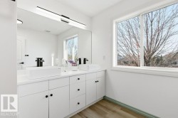 Full bathroom featuring double vanity and light wood finished floors - 