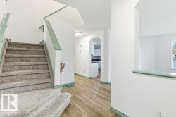 Stairway featuring arched walkways and wood finished floors - 