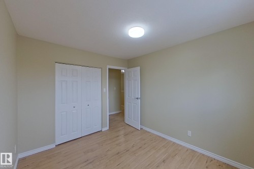 Unfurnished bedroom featuring light wood finished floors and a closet - 112 Dickinsfield Court Nw, Edmonton, AB - Indoor