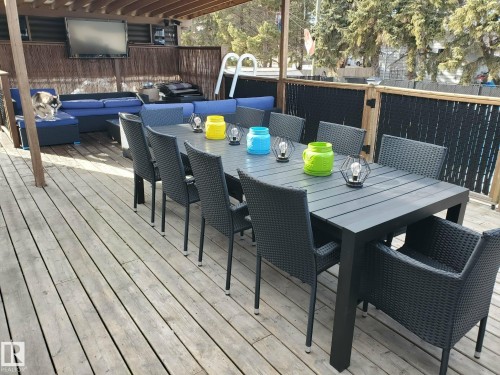 The property features an expansive outdoor deck with wooden flooring, offering ample space for entertaining - 5510 Railway Avenue, Glendon, AB - Outdoor With Deck Patio Veranda With Exterior