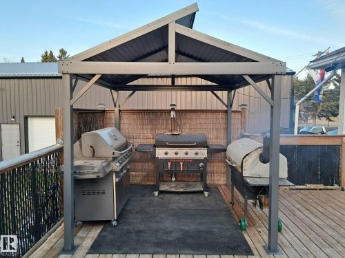 Outdoor deck area featuring a sheltered grilling station with a slatted privacy screen - 5510 Railway Avenue, Glendon, AB - Outdoor With Deck Patio Veranda With Exterior