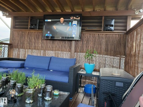 This outdoor space features a covered patio area with a wooden ceiling and a rattan wall covering - 5510 Railway Avenue, Glendon, AB - Outdoor With Deck Patio Veranda With Exterior