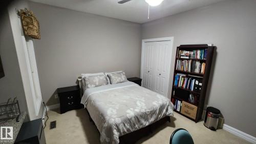 Bedroom with a closet, light colored carpet, and ceiling fan - 1715 69 Street, Edmonton, AB - Indoor Photo Showing Bedroom