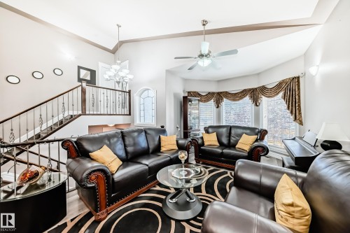 Living room featuring vaulted ceiling, a chandelier, a ceiling fan, and stairs - 1715 69 Street, Edmonton, AB - Indoor Photo Showing Living Room