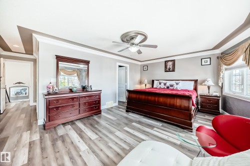 Bedroom with multiple windows, ornamental molding, light wood-type flooring, and ceiling fan - 1715 69 Street, Edmonton, AB - Indoor Photo Showing Bedroom