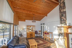 Living room with high vaulted ceiling, wood ceiling, and a chandelier - 