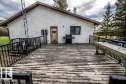 Expansive outdoor deck featuring wood-finish flooring and black metal railings - 
