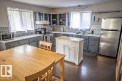 Kitchen featuring gray cabinetry, white countertops, a decorative backsplash, and stainless steel appliances - 