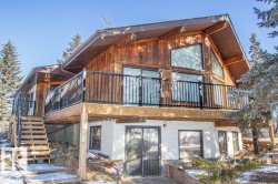 Back of property featuring stairway and a wooden deck - 