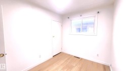 Unfurnished bedroom with light wood-type flooring and baseboards - 