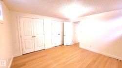 Unfurnished bedroom featuring multiple closets, a textured ceiling, and light wood-type flooring - 