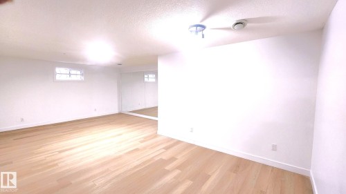 Empty room featuring a textured ceiling and light wood finished floors - 11516 133A Avenue, Edmonton, AB - Indoor Photo Showing Other Room