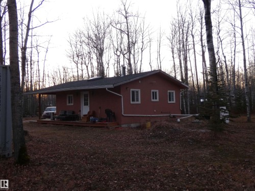 View from the yard, of the side and back of the cabin, also showing trees and spacious yard. - 13 Willow Place, Rural Barrhead County, AB 