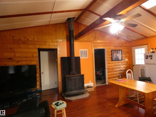Open and airy with slightly vaulted ceiling and a skylight, this shared space lets in natural light for a comfy feel!  The woodstove adds to the ambiance and coziness for those chillier days and nights. - 13 Willow Place, Rural Barrhead County, AB 