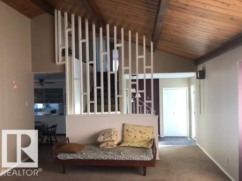 Corridor featuring a wooden ceiling with exposed beams, carpet flooring, and high vaulted ceiling - 4213 42 Avenue, Innisfail, AB - Indoor Photo Showing Other Room