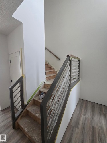 Staircase with wood finished floors and a textured ceiling - 7706 174A Avenue, Edmonton, AB - Indoor Photo Showing Other Room