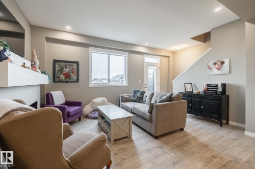 Living area with light wood-style flooring and baseboards - 5 2072 Wonnacott Way, Edmonton, AB - Indoor Photo Showing Living Room
