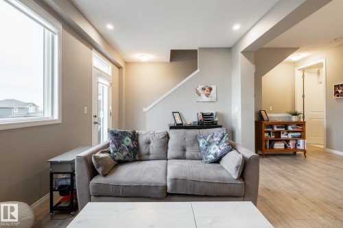 Living room featuring hardwood / wood-style floors and baseboards - 5 2072 Wonnacott Way, Edmonton, AB - Indoor