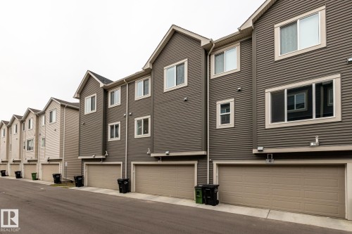 Back of house with a garage and a residential view - 5 2072 Wonnacott Way, Edmonton, AB - Outdoor
