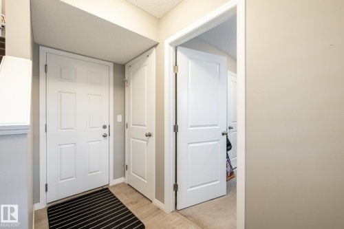 Entryway with wood finished floors and a textured ceiling - 5 2072 Wonnacott Way, Edmonton, AB - Indoor Photo Showing Other Room