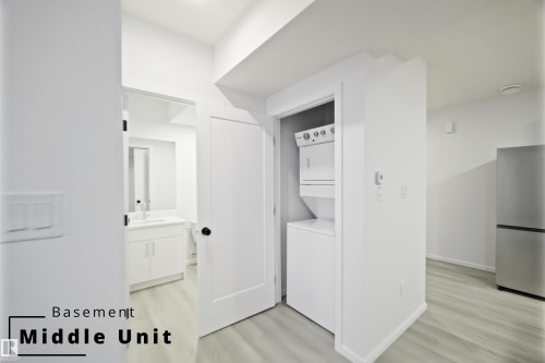 Laundry room featuring light wood-style floors and stacked washer / dryer - 7585 174A Avenue, Edmonton, AB - Indoor Photo Showing Laundry Room