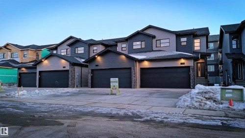 View of front of property featuring driveway and stone siding - 7585 174A Avenue, Edmonton, AB - Outdoor With Facade
