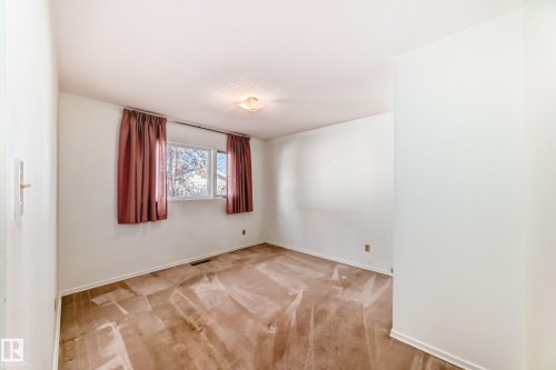 Empty room with light colored carpet and baseboards - Edmonton, AB - Indoor Photo Showing Other Room