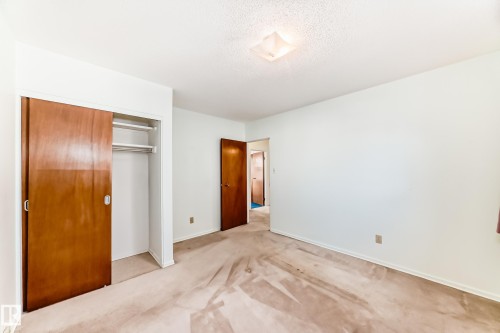 Unfurnished bedroom featuring carpet, a closet, and a textured ceiling - Edmonton, AB - Indoor Photo Showing Other Room