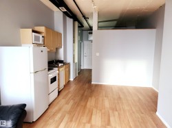 Kitchen featuring white appliances, light brown cabinetry, and light wood finished floors - 