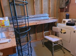 Washroom featuring finished concrete floors, electric panel, and washer and dryer - 