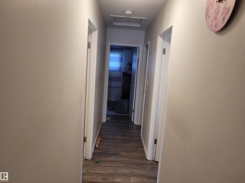 Hall with dark wood-style floors, a textured ceiling, and attic access - 11616 152 Avenue, Edmonton, AB - Indoor Photo Showing Other Room