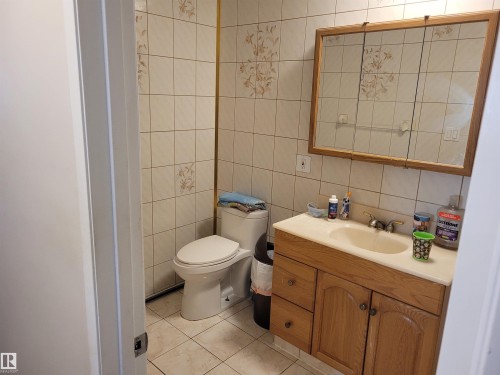 Bathroom with vanity, tile walls, decorative backsplash, and light tile patterned flooring - 11616 152 Avenue, Edmonton, AB - Indoor Photo Showing Bathroom
