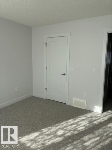Unfurnished room featuring dark carpet and a textured ceiling - 2433 Glenridding Boulevard, Edmonton, AB - Indoor Photo Showing Other Room